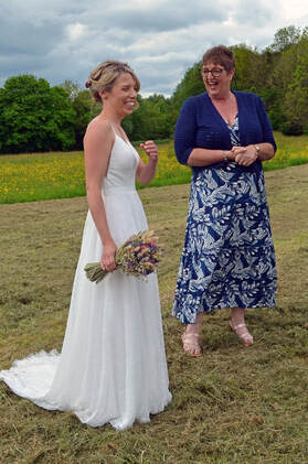 Bride with wedding bouquet and female celebrant in blue dress